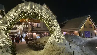 a building covered in snow at night with lights at Apartments Seventy Seven in Kranjska Gora