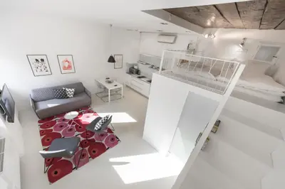 a small white room with a bed and a chair at Fine Ljubljana Apartments in Ljubljana