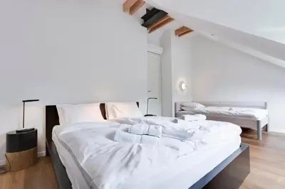 a bedroom with two beds with white sheets at Fine Ljubljana Apartments in Ljubljana