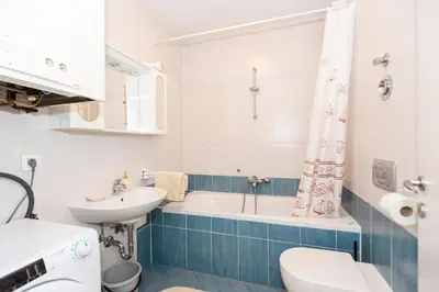 a bathroom with a sink and a tub and a toilet at Apartment Lakeside Cerknica in Cerknica