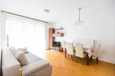 a living room with a couch and a table and chairs at Apartment Lakeside Cerknica in Cerknica