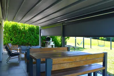 a patio with a wooden table and chairs at Domačija Vrški in Slovenska Bistrica