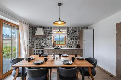 a dining room with a wooden table and chairs at Domačija Vrški in Slovenska Bistrica