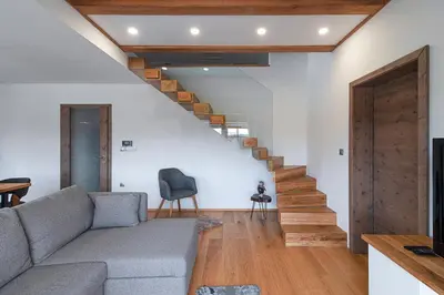 a living room with a couch and wooden stairs at Domačija Vrški in Slovenska Bistrica