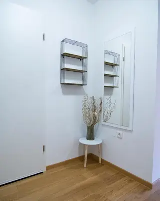 a vase on a table in a room with a mirror at Apartma Tia in Zreče