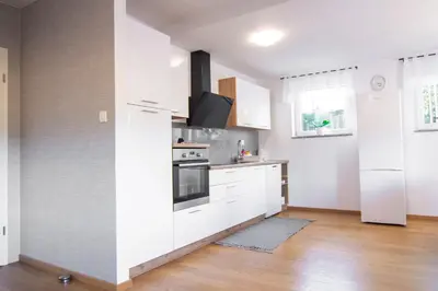 a kitchen with white cabinets and a refrigerator at Apartma Tia in Zreče