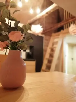 a vase with flowers sitting on top of a table at Alpine Spirit - Family Apartment in Kranjska Gora