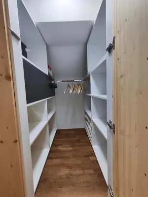 a walk in closet with white shelves at Alpine Spirit - Family Apartment in Kranjska Gora