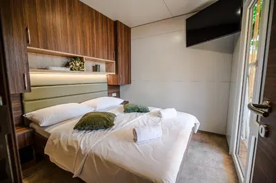 a bedroom with a bed with white sheets and pillows at Premium Mobile Homes with Thermal Riviera Tickets in Čatež ob Savi