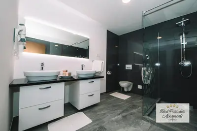a bathroom with two sinks and a shower at Wellness Paradise Apartment in Bled