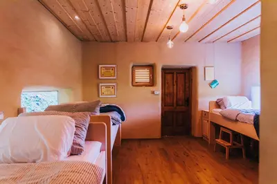 a room with three beds and a wooden floor at Sleeping with bees - Tourist farm Muha in Grosuplje
