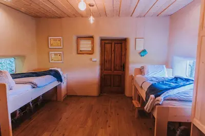 a room with two beds and a wooden floor at Sleeping with bees - Tourist farm Muha in Grosuplje