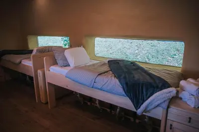 two beds in a small room with a window at Sleeping with bees - Tourist farm Muha in Grosuplje