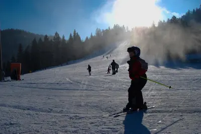 a group of people skiing down a snow covered slope at APARTMA NIKA in Ribnica na Pohorju