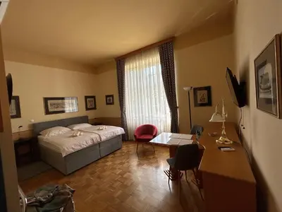 a bedroom with a bed and a table and a desk at Apartma Vila Golf in Rogaška Slatina