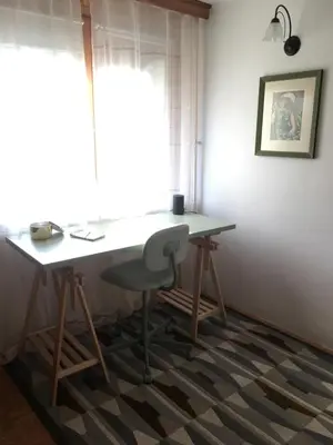 a desk and a chair in a room with a window at Road View Apartment Celeia in Celje