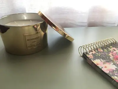 a candle and a wand on a table with a notebook at Road View Apartment Celeia in Celje