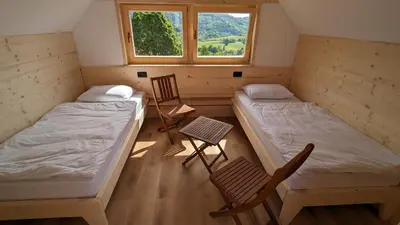 a room with two beds and a chair and a window at GoLife Center Glamping in Laze v Tuhinju