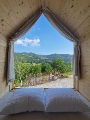 a bed in a room with a window at GoLife Center Glamping in Laze v Tuhinju