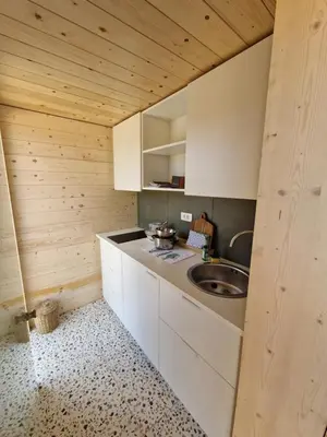 a kitchen with white cabinets and a sink at GoLife Center Glamping in Laze v Tuhinju