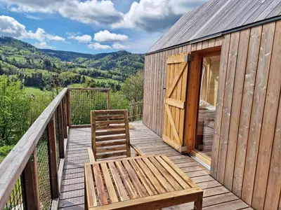 a wooden deck with a bench and a door at GoLife Center Glamping in Laze v Tuhinju