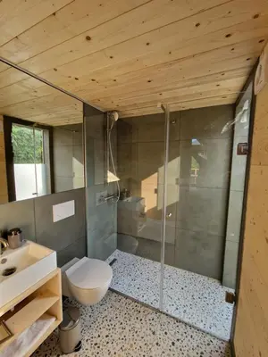 a bathroom with a shower and a toilet and a sink at GoLife Center Glamping in Laze v Tuhinju