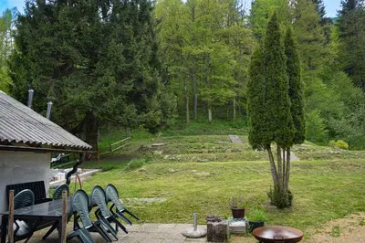 a group of chairs and a table in a garden at Grajska kmetija in Kočevje