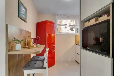 a small kitchen with a red refrigerator and a table at Angel Boutique Home - Entire premium house in Laško