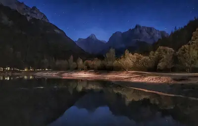 a painting of a lake at night with mountains at Apartma Uršič in Kranjska Gora