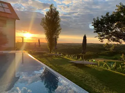 a swimming pool with a sunset in the background at SIBON Wine & Spa Resort Jeruzalem in Ljutomer