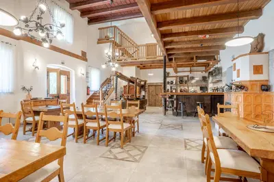 a restaurant with wooden tables and chairs and a staircase at SIBON Wine & Spa Resort Jeruzalem in Ljutomer