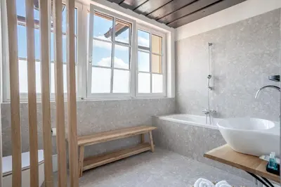 a bathroom with a tub and a sink and a window at SIBON Wine & Spa Resort Jeruzalem in Ljutomer