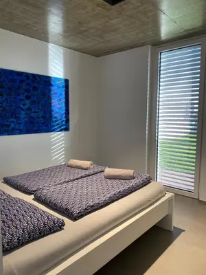 a bed in a bedroom with a painting on the wall at VOO residence in Malečnik