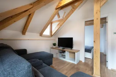 a living room with a couch and a tv at Bright & Spacious Loft In The Heart Of Old Town in Ljubljana