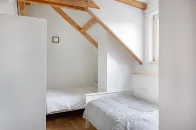 a attic bedroom with two beds and a window at Bright & Spacious Loft In The Heart Of Old Town in Ljubljana