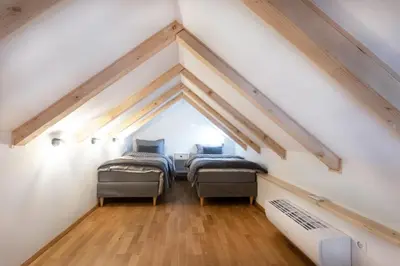 a room with three beds in a attic at Bright & Spacious Loft In The Heart Of Old Town in Ljubljana
