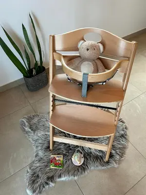 a teddy bear sitting in a wooden chair at HOLIDAY HOUSE - River Bača in Most na Soči