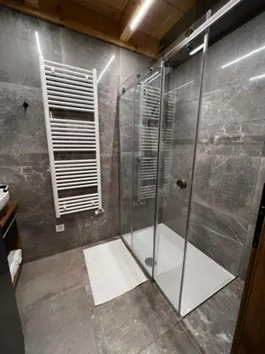 a shower with a glass door in a bathroom at HOLIDAY HOUSE - River Bača in Most na Soči