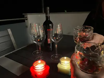 a table with three wine glasses and a bottle of wine at HOLIDAY HOUSE - River Bača in Most na Soči
