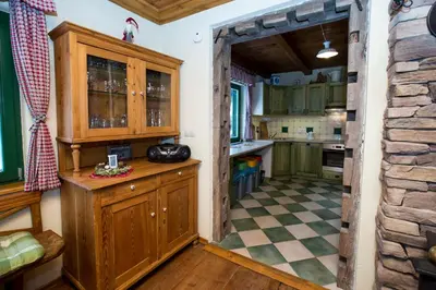 a kitchen with wooden cabinets and a checkered floor at Cottage Suha in Bohinj