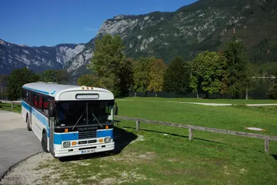 a blue and white bus parked on the side of a road at Cottage Suha in Bohinj