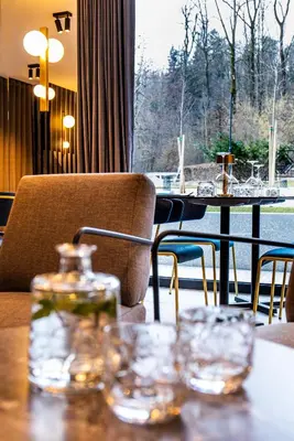 a table with glasses on top of a table with a window at Hotel Čad in Ljubljana