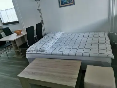 a bed in a room with a table and chairs at Apartma Kuhar in Kranjska Gora