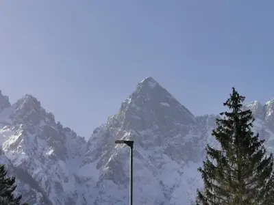 a street light in front of a snow covered mountain at Apartma Kuhar in Kranjska Gora