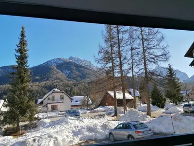 a view from the window of a house in the snow at Apartma Kuhar in Kranjska Gora