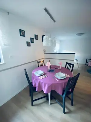 a dining room table with a pink table cloth and chairs at Apartma KAMNITNK in Škofja Loka