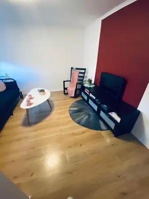 a living room with a television and a table at Apartma KAMNITNK in Škofja Loka