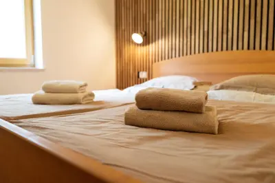 two folded towels sitting on top of a bed at Organic Tourist Farm Pri Plajerju in Trenta