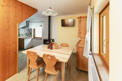 a kitchen with a wooden table and chairs at Organic Tourist Farm Pri Plajerju in Trenta