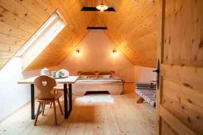 a bedroom with a bed and a desk in a attic at Organic Tourist Farm Pri Plajerju in Trenta
